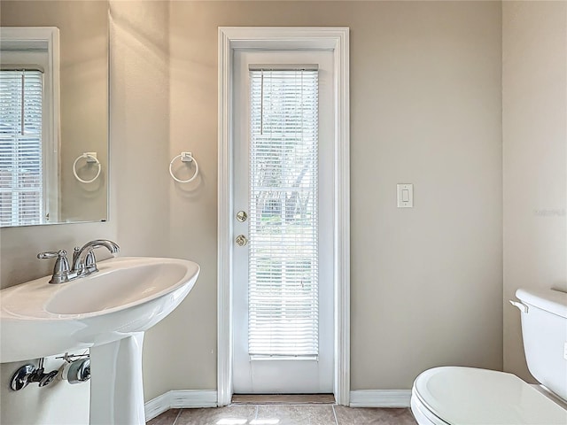 bathroom featuring a sink, baseboards, and toilet