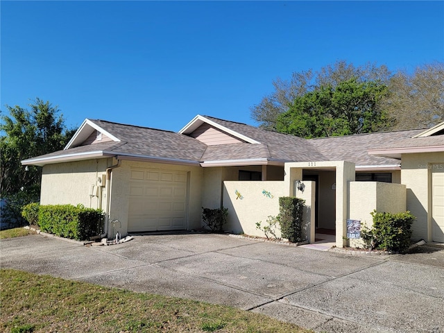 view of front of house with stucco siding, a garage, roof with shingles, and concrete driveway