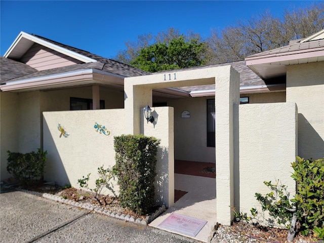 entrance to property featuring stucco siding