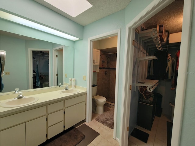 bathroom featuring a sink, a skylight, double vanity, and tile patterned flooring