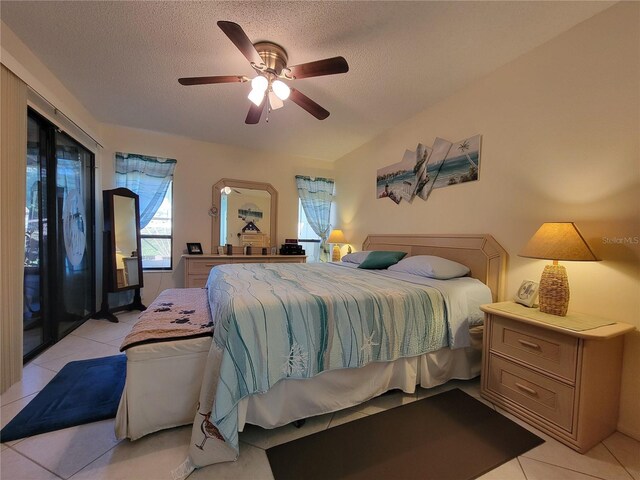 bedroom with ceiling fan, access to outside, light tile patterned floors, and a textured ceiling