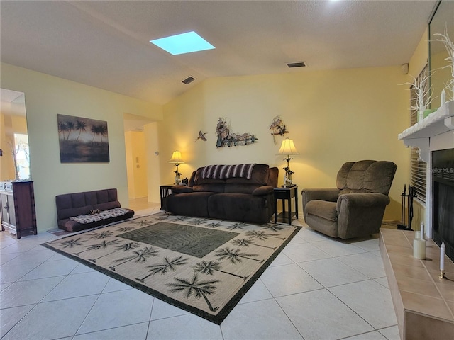 living room featuring light tile patterned flooring, visible vents, a fireplace with raised hearth, and vaulted ceiling