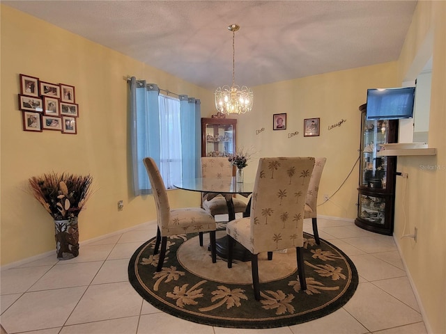 dining space with light tile patterned floors, a chandelier, and baseboards