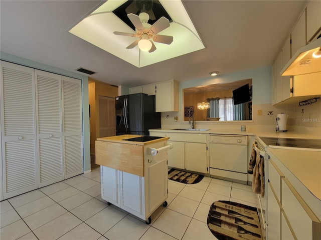 kitchen with visible vents, light countertops, light tile patterned flooring, white appliances, and a sink