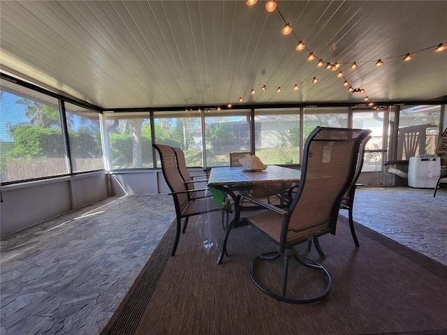 sunroom / solarium featuring track lighting and wooden ceiling