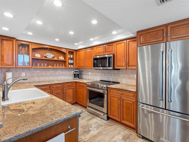 kitchen featuring open shelves, a sink, decorative backsplash, stainless steel appliances, and brown cabinets