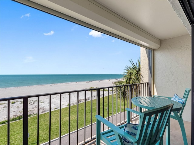 balcony with a water view and a beach view