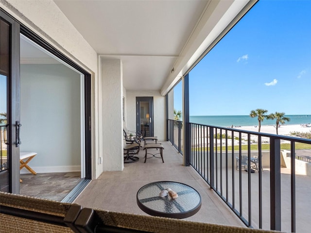 balcony featuring a view of the beach and a water view