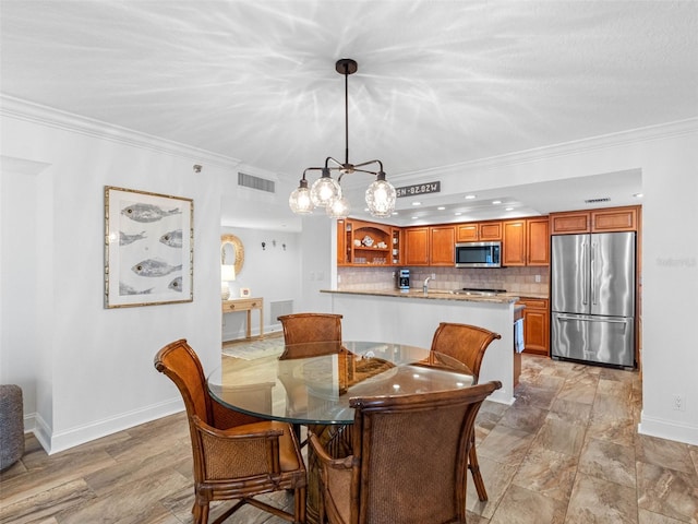 dining room featuring baseboards, visible vents, and ornamental molding