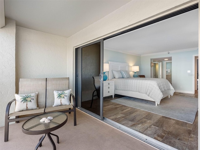 bedroom featuring ensuite bath, a textured wall, baseboards, and ornamental molding