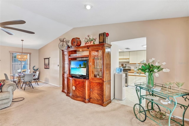 living room featuring light colored carpet, ceiling fan with notable chandelier, baseboards, and vaulted ceiling