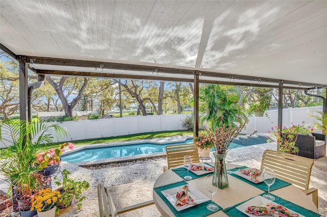 view of pool with a fenced backyard, outdoor dining space, a fenced in pool, and a patio