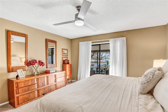 carpeted bedroom with access to outside, a ceiling fan, baseboards, and a textured ceiling