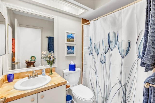 bathroom featuring a shower with shower curtain, toilet, and vanity