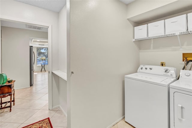 laundry area featuring light tile patterned floors, visible vents, baseboards, laundry area, and independent washer and dryer