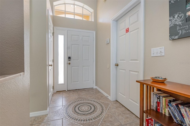 entrance foyer with tile patterned floors, baseboards, and plenty of natural light