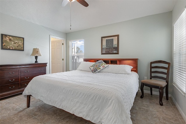 bedroom with multiple windows, baseboards, and ceiling fan