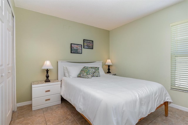 bedroom with tile patterned flooring and baseboards