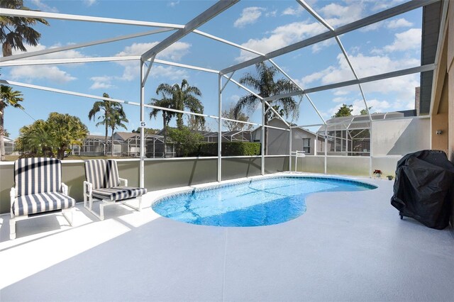 outdoor pool featuring a grill, a lanai, and a patio area