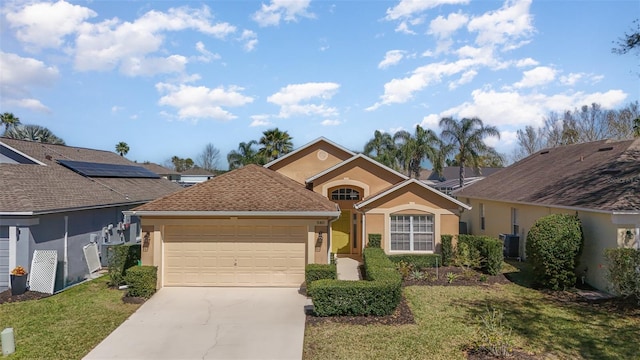 single story home featuring concrete driveway, a front yard, central AC unit, stucco siding, and an attached garage