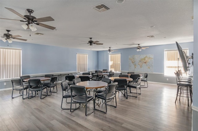 dining space featuring visible vents, baseboards, and wood finished floors