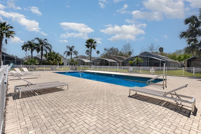 pool with a patio area and fence