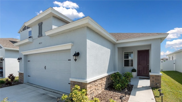 view of front of home featuring stucco siding, fence, roof with shingles, concrete driveway, and an attached garage