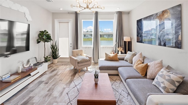 living room featuring a chandelier, visible vents, and wood finished floors