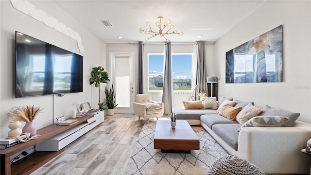 living area featuring wood finished floors, visible vents, and a chandelier