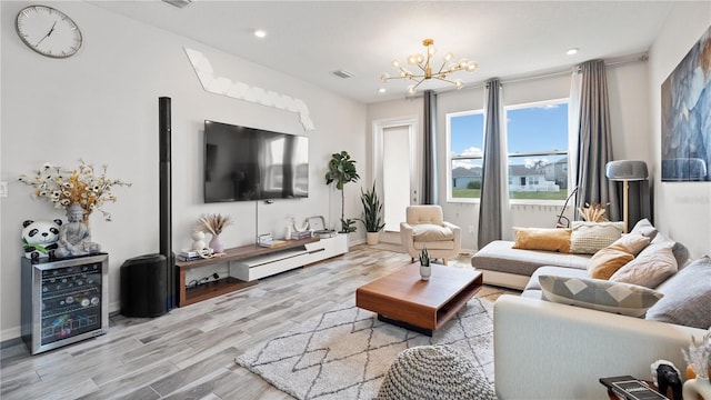 living room featuring a notable chandelier, recessed lighting, visible vents, and wood finished floors