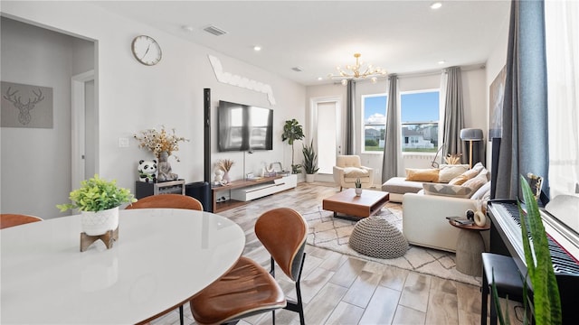 living area featuring recessed lighting, visible vents, light wood-style flooring, and an inviting chandelier