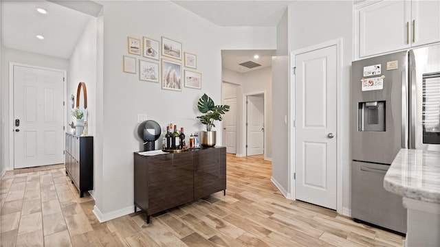 hallway with light wood finished floors, recessed lighting, and baseboards