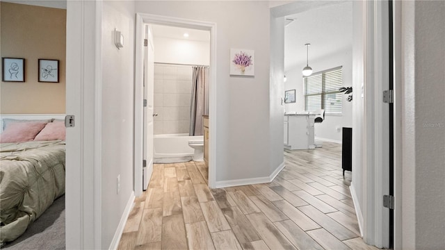 hallway with baseboards and light wood-style flooring