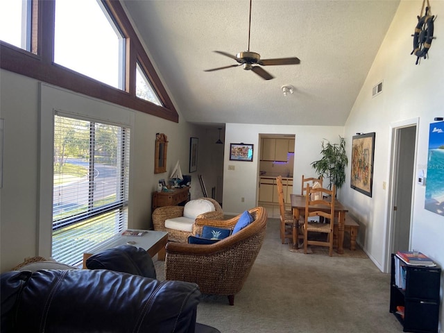 carpeted living area featuring visible vents, a textured ceiling, high vaulted ceiling, and a ceiling fan