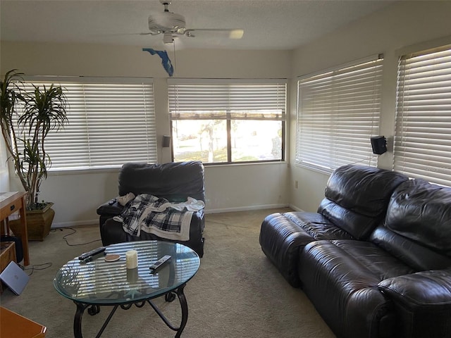 living room with baseboards, light carpet, and ceiling fan