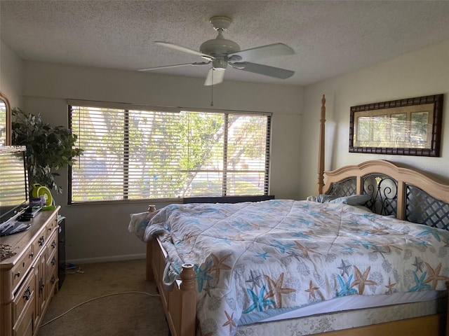 carpeted bedroom featuring baseboards, multiple windows, a textured ceiling, and ceiling fan