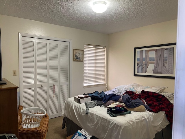 carpeted bedroom with a closet and a textured ceiling