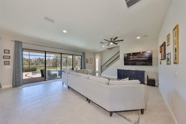 living room with visible vents, baseboards, recessed lighting, arched walkways, and stairs