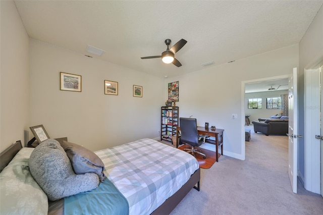 bedroom with ceiling fan, baseboards, visible vents, and light carpet