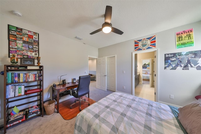 bedroom featuring visible vents, carpet, ceiling fan, and a textured ceiling