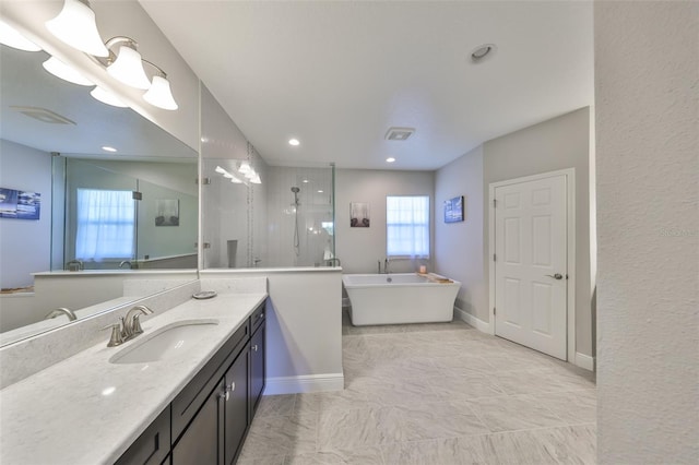 full bathroom with a freestanding tub, baseboards, walk in shower, and vanity