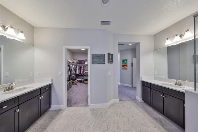 full bathroom with a sink, visible vents, and two vanities