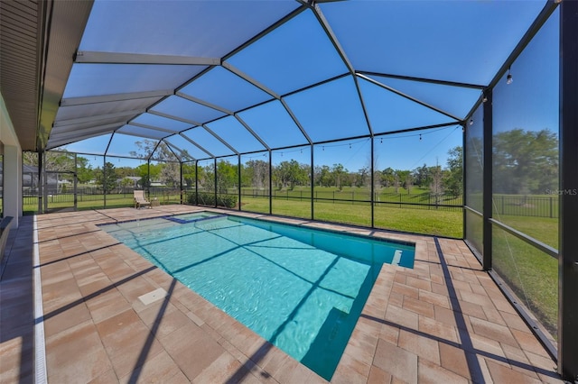 outdoor pool featuring a patio area, glass enclosure, and a yard