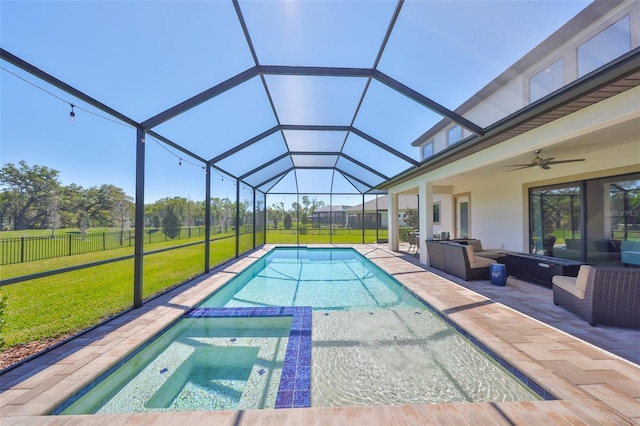 view of swimming pool featuring glass enclosure, a patio, a ceiling fan, a yard, and a pool with connected hot tub