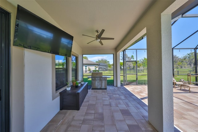 view of patio / terrace with a lanai, a ceiling fan, and a grill