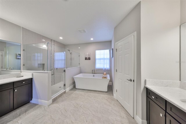 bathroom with a freestanding tub, recessed lighting, a shower stall, baseboards, and vanity