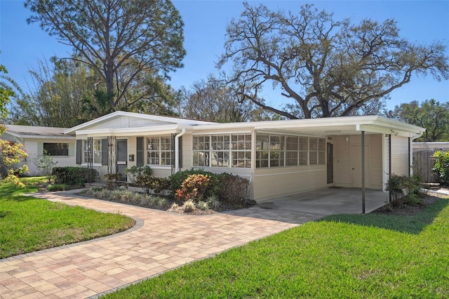 rear view of property with a yard and an attached carport