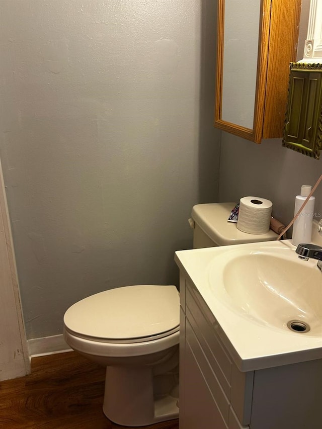 bathroom with vanity, toilet, and wood finished floors