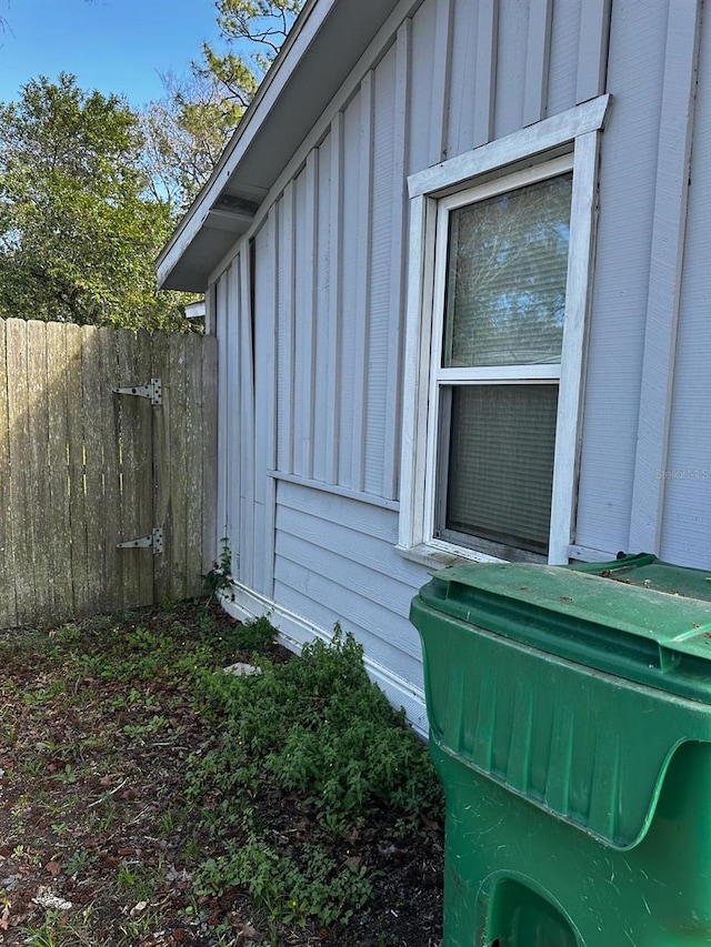 view of side of property with fence and board and batten siding