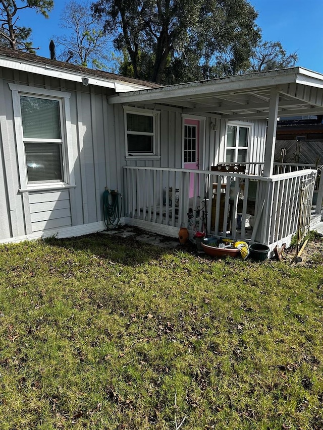 entrance to property featuring a yard and board and batten siding